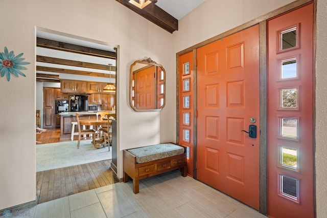 foyer featuring light hardwood / wood-style floors and beam ceiling