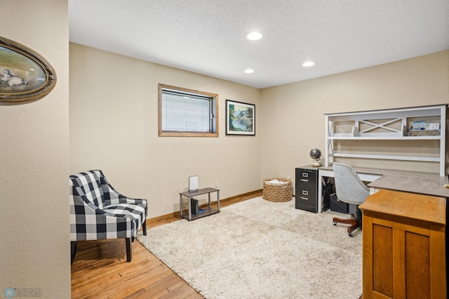 office area featuring light hardwood / wood-style floors and a textured ceiling