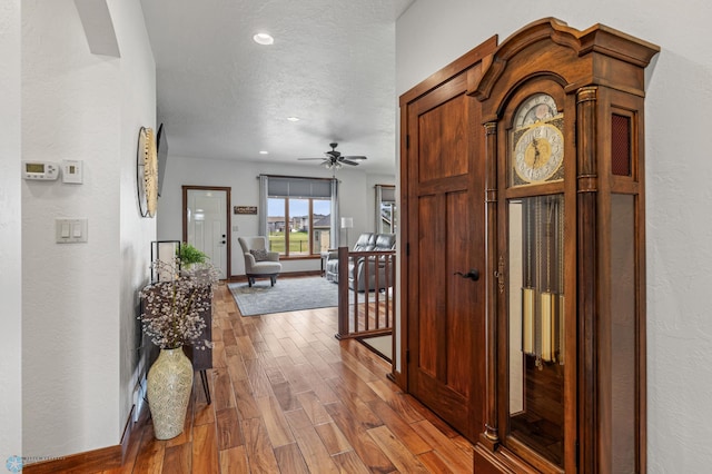 hallway with hardwood / wood-style flooring and a textured ceiling