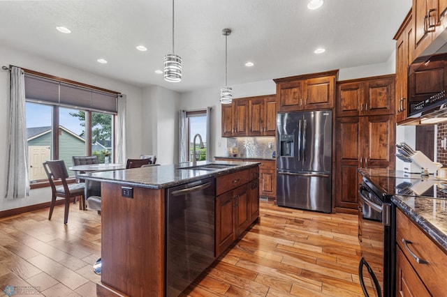 kitchen with stainless steel appliances, light hardwood / wood-style flooring, a kitchen island, and sink