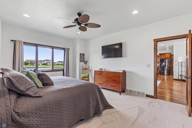 bedroom featuring ceiling fan, stainless steel refrigerator with ice dispenser, and light wood-type flooring