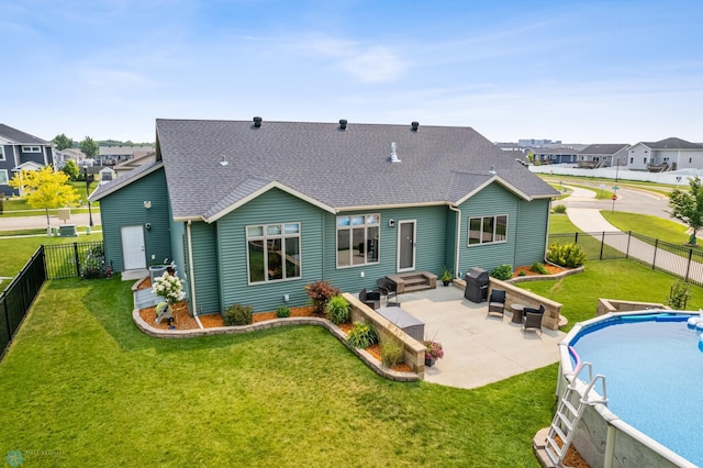 rear view of house with a patio and a lawn