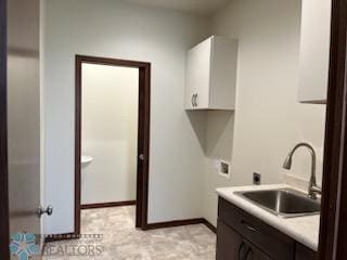 laundry area featuring hookup for an electric dryer, sink, cabinets, hookup for a washing machine, and light tile patterned floors