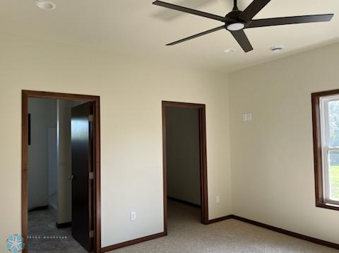 unfurnished bedroom with multiple windows, carpet, and ceiling fan