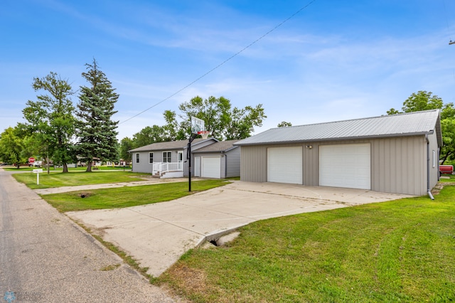 view of front of property with a garage, an outdoor structure, and a front yard