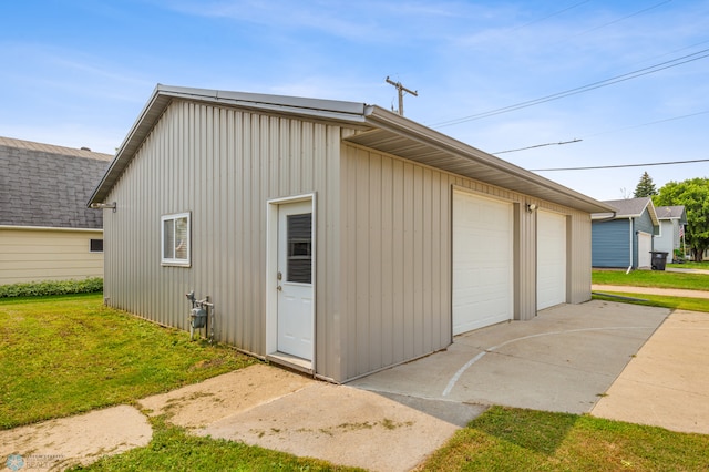 exterior space with a garage and a lawn