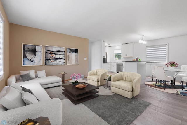 living room featuring a notable chandelier and light wood-type flooring