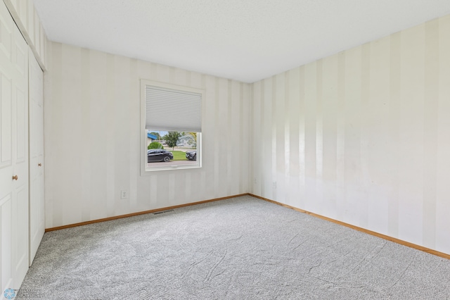 spare room featuring light carpet