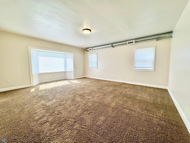 carpeted spare room featuring a healthy amount of sunlight