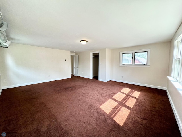 unfurnished room with dark colored carpet