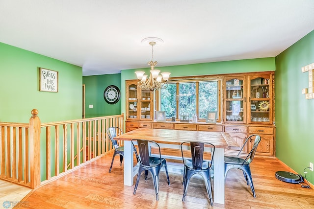 dining area featuring light hardwood / wood-style flooring and a notable chandelier