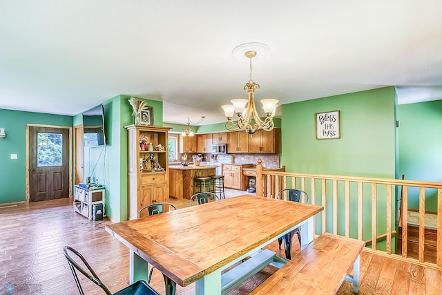 dining space with light hardwood / wood-style flooring and a chandelier