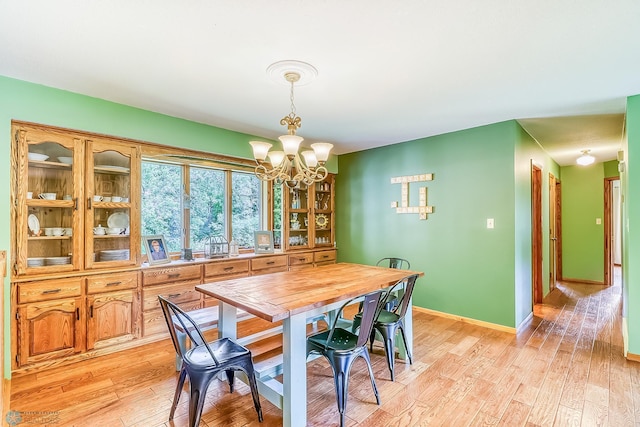 dining area featuring light hardwood / wood-style floors and an inviting chandelier