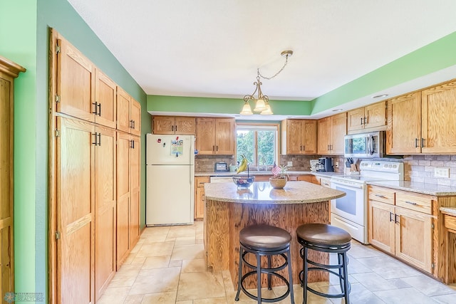 kitchen with white appliances, tasteful backsplash, a breakfast bar, and a kitchen island