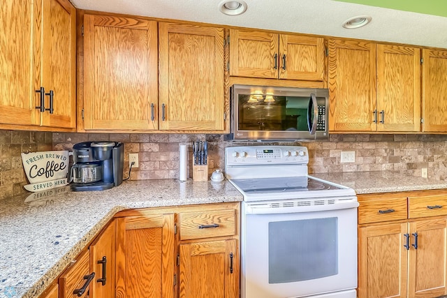 kitchen with backsplash, white electric range oven, and light stone counters