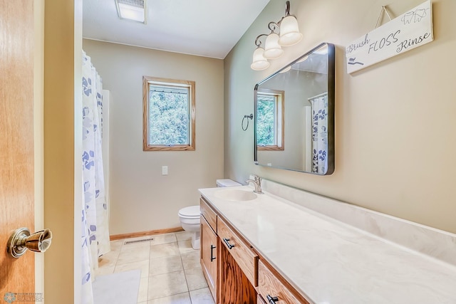 bathroom with toilet, vanity, and tile patterned floors