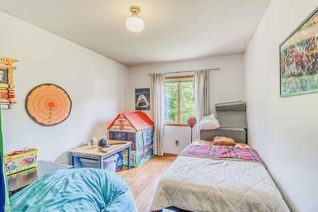 bedroom with hardwood / wood-style floors and a textured ceiling