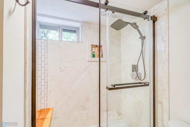 bathroom featuring toilet, a textured ceiling, and a shower with shower door