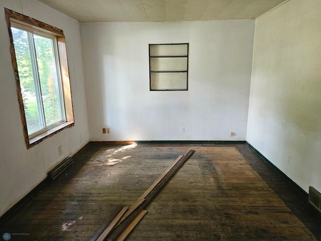 unfurnished room featuring built in features and dark hardwood / wood-style floors