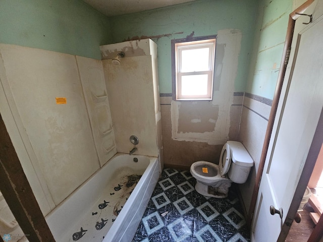 bathroom featuring shower / washtub combination, tile patterned flooring, toilet, and tile walls