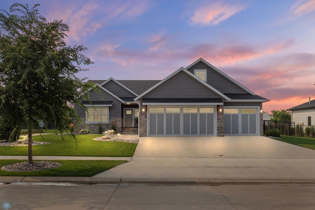 craftsman house featuring a garage and a lawn