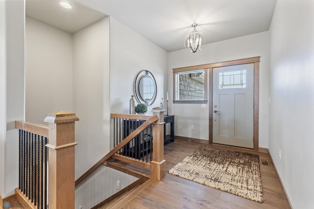 entryway featuring hardwood / wood-style flooring and a notable chandelier