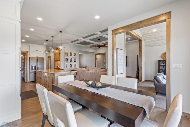 dining area featuring beamed ceiling, ceiling fan, light hardwood / wood-style floors, and coffered ceiling