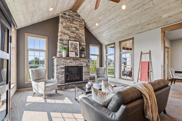 living room with beam ceiling, ceiling fan, wooden ceiling, a stone fireplace, and high vaulted ceiling