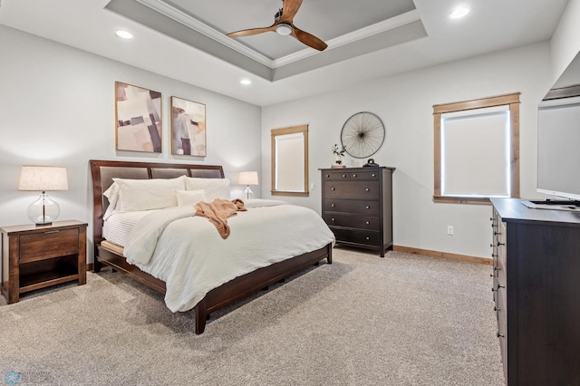 carpeted bedroom featuring ceiling fan and a raised ceiling