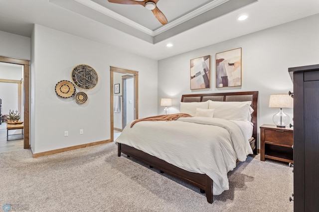 bedroom with light carpet, ceiling fan, and a tray ceiling