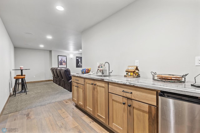 kitchen featuring sink, light hardwood / wood-style flooring, dishwasher, and light stone counters