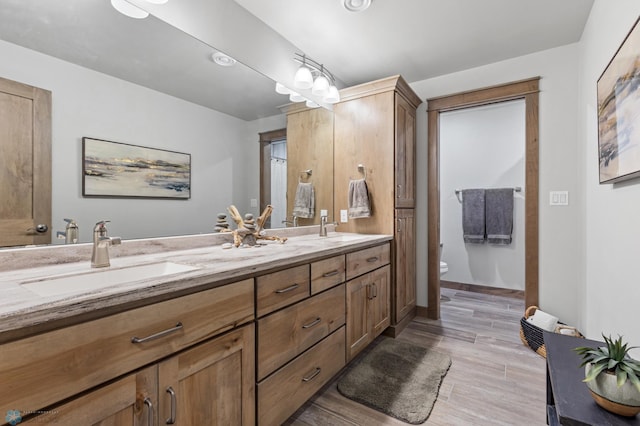 bathroom with dual vanity and toilet