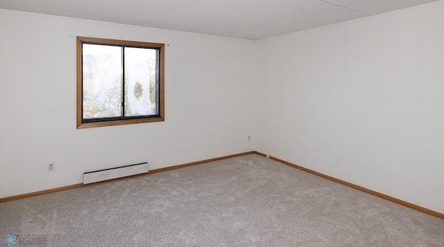 empty room featuring a baseboard heating unit and carpet floors