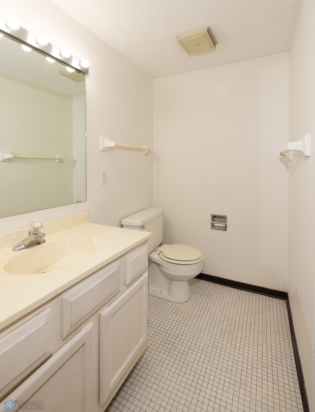 bathroom featuring vanity, toilet, and tile patterned floors