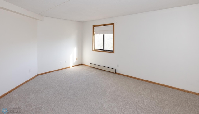 carpeted spare room featuring a baseboard heating unit