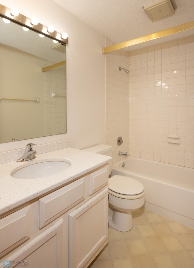 full bathroom with vanity, toilet, tiled shower / bath combo, and a textured ceiling