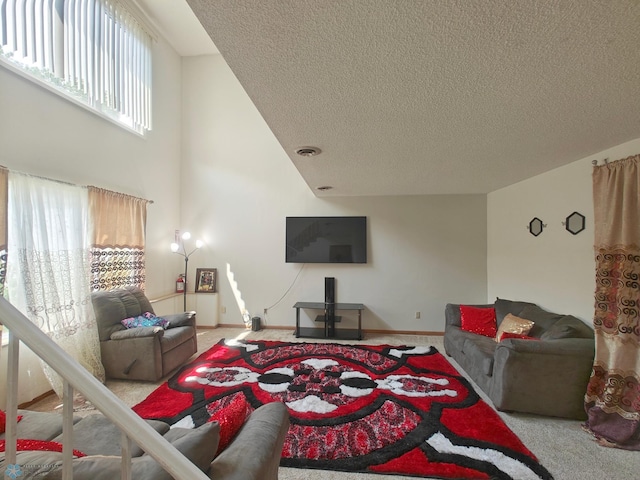 bedroom with carpet flooring, a textured ceiling, and a high ceiling