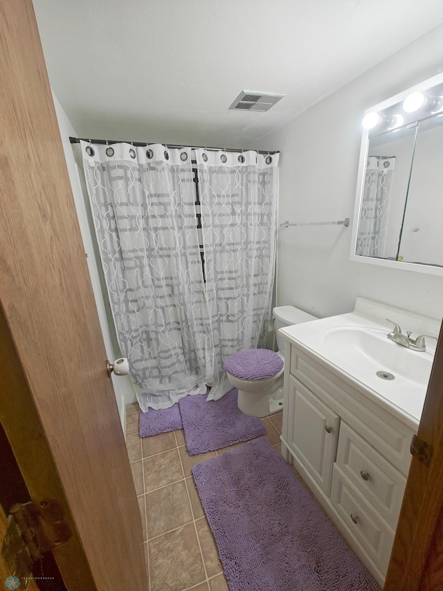 bathroom featuring vanity, tile patterned flooring, and toilet