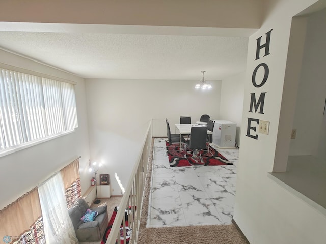 living room featuring tile patterned floors, a textured ceiling, and a notable chandelier