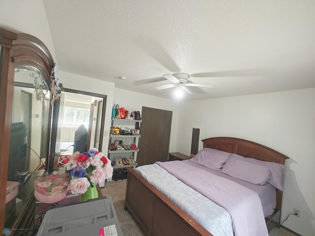 bedroom featuring carpet, ceiling fan, and a textured ceiling