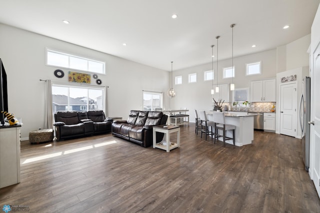 living room featuring dark hardwood / wood-style flooring, plenty of natural light, and a high ceiling