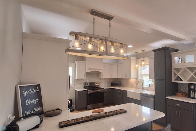 kitchen featuring appliances with stainless steel finishes, tasteful backsplash, sink, decorative light fixtures, and white cabinetry