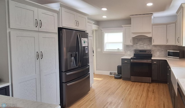 kitchen with stainless steel appliances, tasteful backsplash, and light wood-type flooring