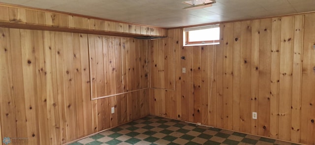 basement with dark tile patterned floors and wooden walls