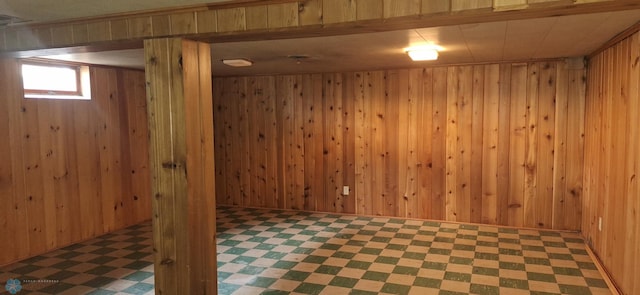 basement featuring tile patterned floors and wood walls