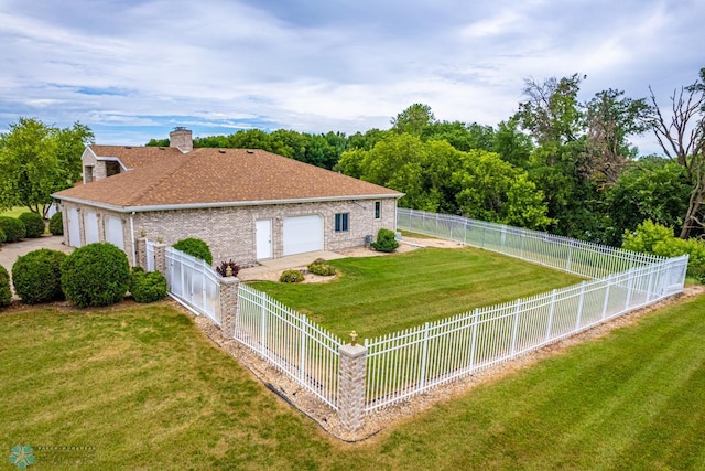 rear view of property with a garage and a yard