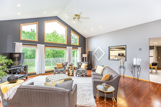 living room featuring wood-type flooring, ceiling fan, high vaulted ceiling, and a healthy amount of sunlight