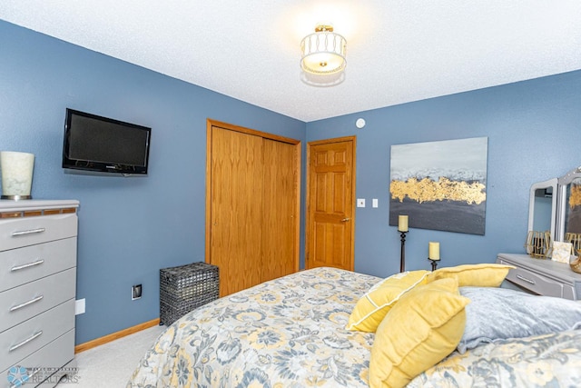 bedroom featuring light carpet, a closet, and a textured ceiling