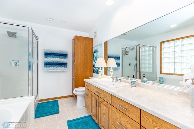 bathroom featuring tile patterned floors, vanity, a bathing tub, and toilet