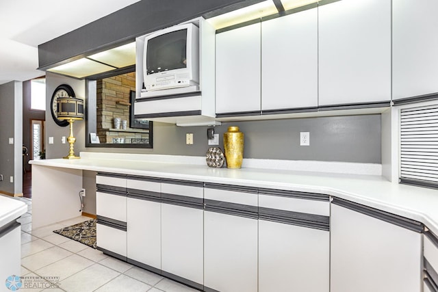 kitchen with light tile patterned floors and white cabinets